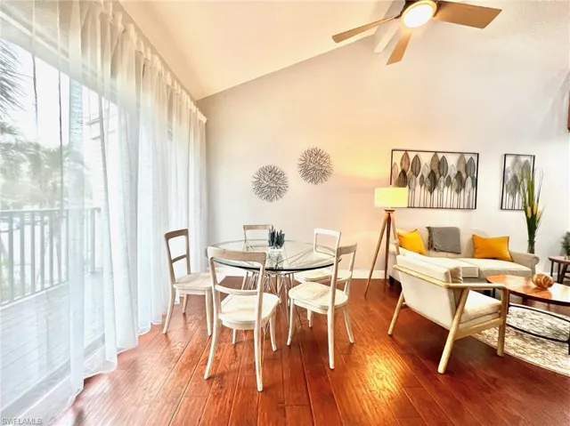 Dining room featuring vaulted ceiling, wood finished floors, baseboards, and ceiling fan
