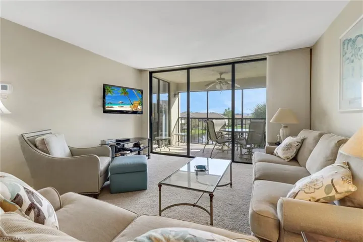 Living room featuring floor to ceiling windows and carpet floors