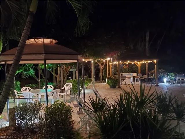 Pool at twilight featuring outdoor dining space, a patio, and a gazebo