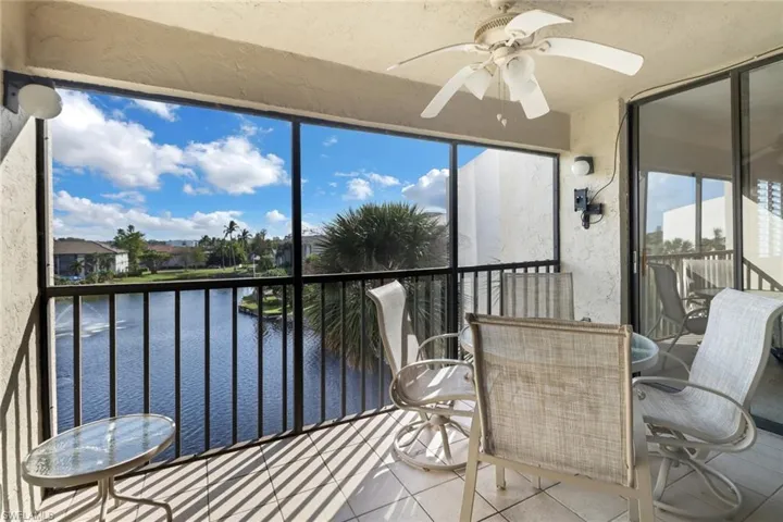 Sunroom / solarium featuring a water view and ceiling fan