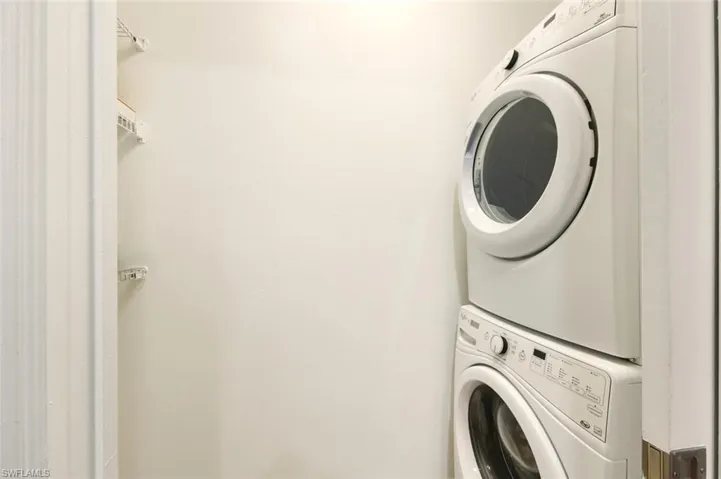 Laundry room with stacked washer and clothes dryer