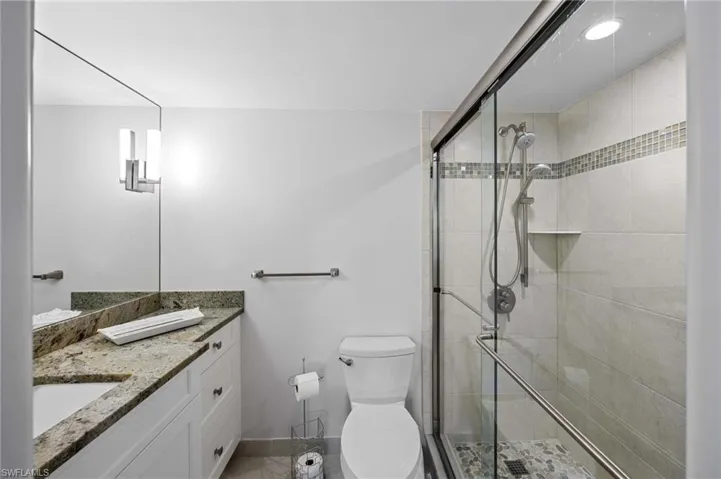 Bathroom with vanity, a shower stall, and light tile patterned floors