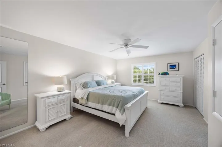 Bedroom featuring light colored carpet, a closet, and ceiling fan