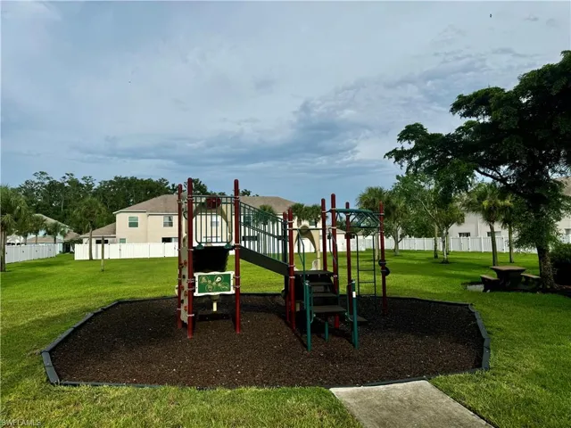 View of jungle gym featuring a lawn