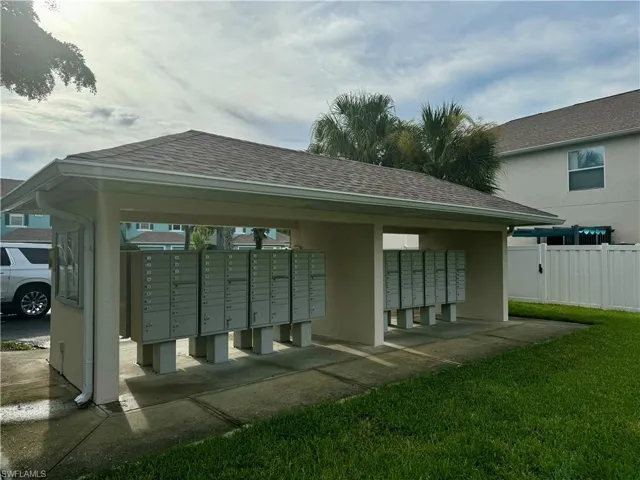 View of property's community with mail boxes and a yard