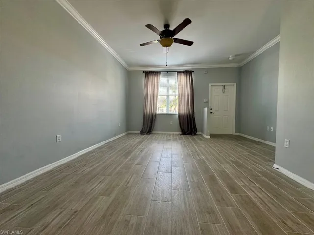 Unfurnished room with wood-type flooring, crown molding, and ceiling fan