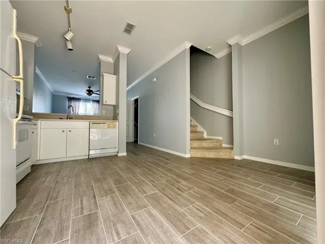 Unfurnished living room with ornamental molding, light hardwood / wood-style floors, and ceiling fan