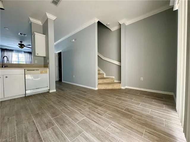 Kitchen with dishwasher, sink, white cabinets, ornamental molding, and ceiling fan