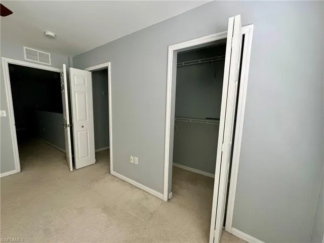 Unfurnished bedroom with light colored carpet and a closet