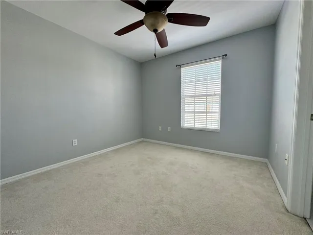 Carpeted spare room with ceiling fan