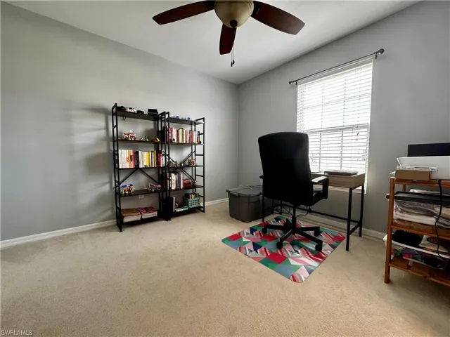 Office with light carpet and ceiling fan