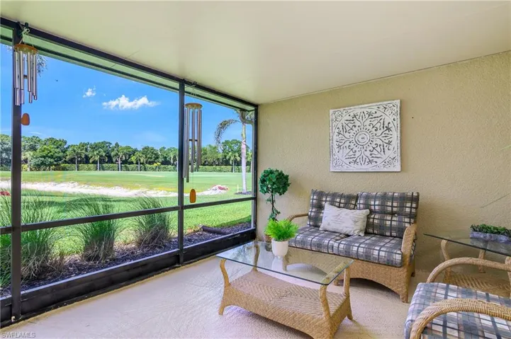Sunroom / solarium with view of golf course and view of scattered trees