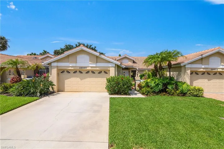 View of front of property featuring a garage, driveway, a front lawn, and stucco siding