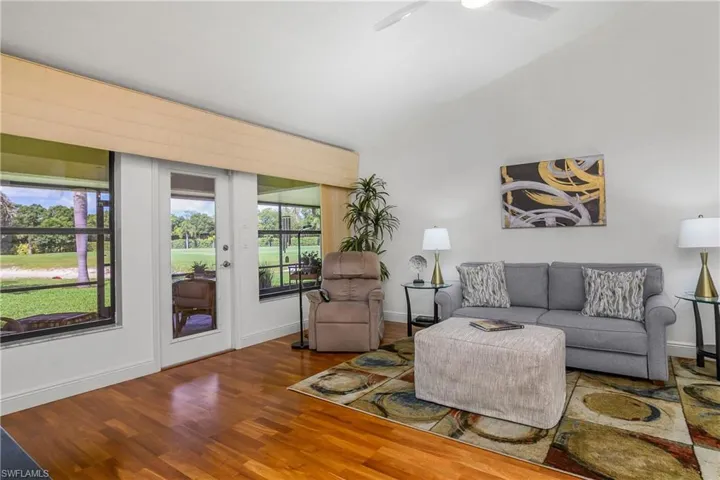Living room with wood finished floors, a ceiling fan, and baseboards