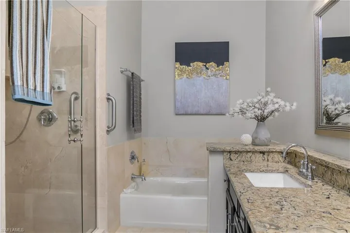 Full bathroom featuring a shower stall, a bath, and vanity