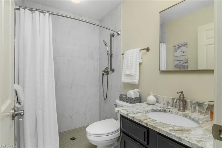 Bathroom with vanity, toilet, and a tile shower