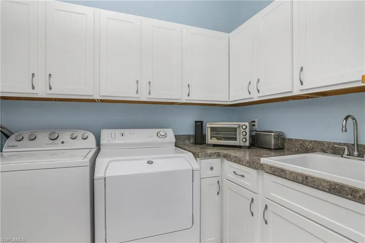 Washroom featuring cabinet space and washing machine and clothes dryer