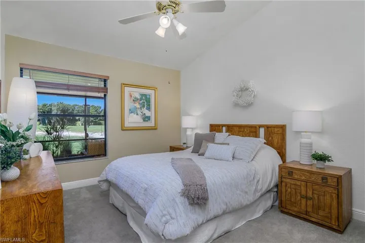 Carpeted bedroom featuring baseboards, lofted ceiling, and ceiling fan