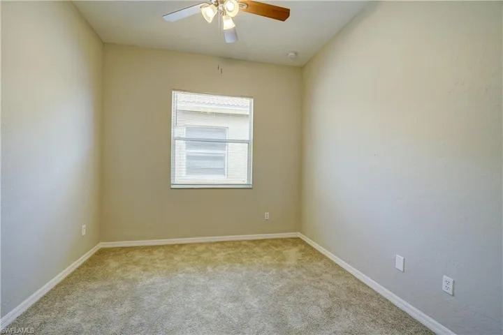 Unfurnished room with ceiling fan and carpet floors