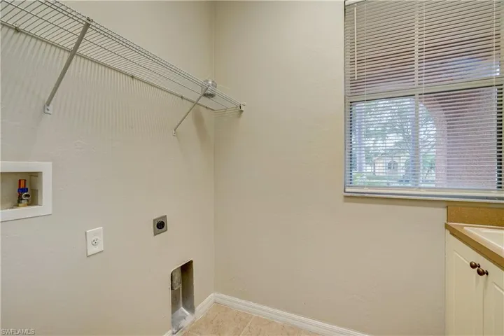 Washroom featuring light tile floors, hookup for an electric dryer, and washer hookup