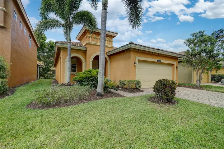 Mediterranean / spanish home with a front yard and a garage