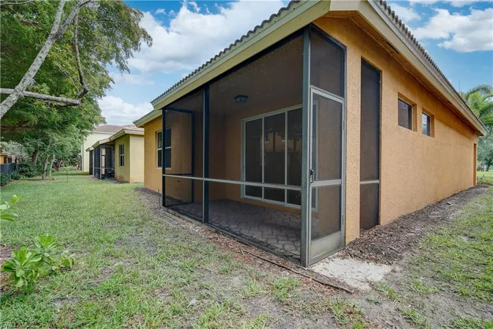 View of side of property featuring a sunroom and a lawn