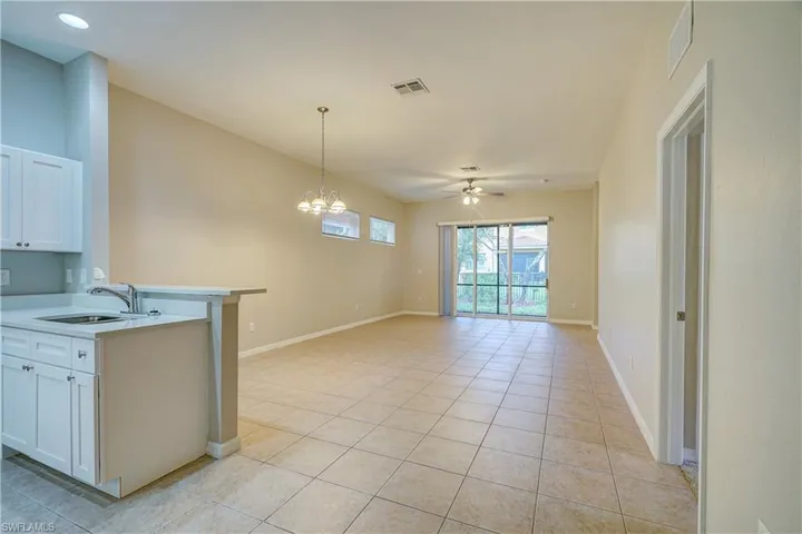 Kitchen with sink, light tile flooring, and white cabinetry