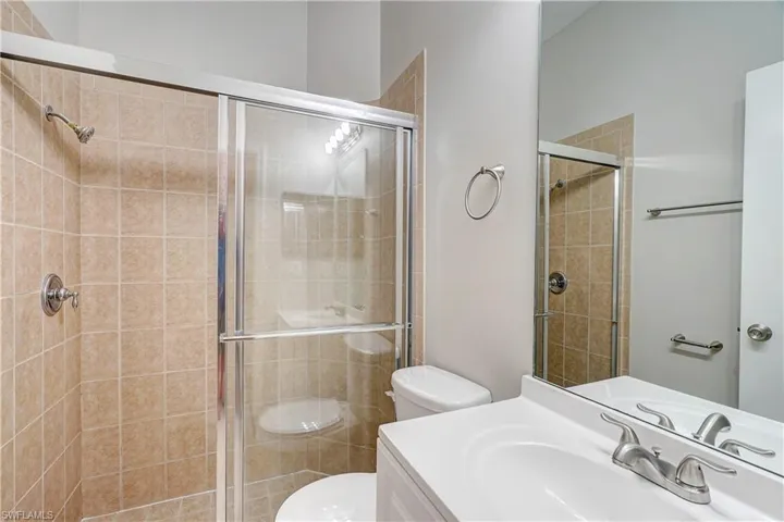 Bathroom featuring walk in shower, oversized vanity, and toilet