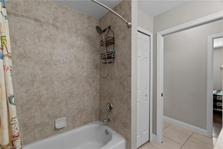 Full bathroom featuring shower / tub combo, a closet, and light tile patterned floors