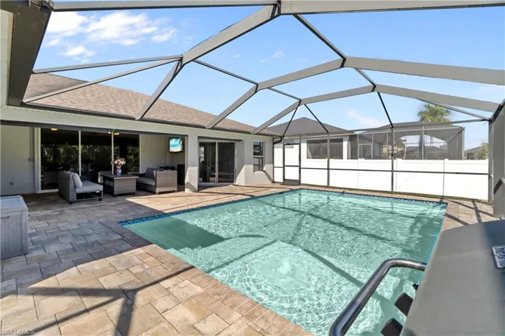 View of swimming pool featuring a lanai, a sunroom, outdoor lounge area, and a patio