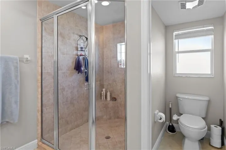 Full bathroom with toilet and a stall shower