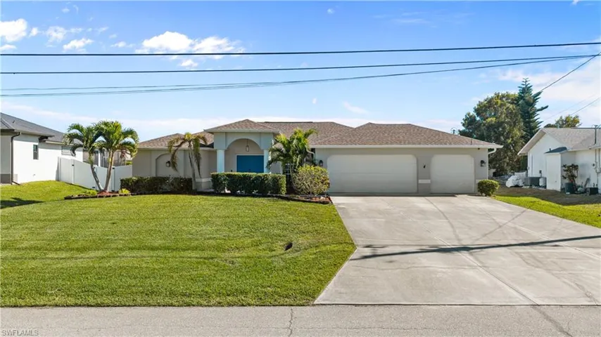 View of front of home featuring a front yard, stucco siding, concrete driveway, and a garage