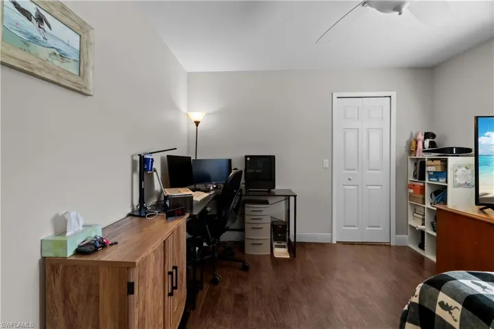Home office with dark wood-style flooring and baseboards