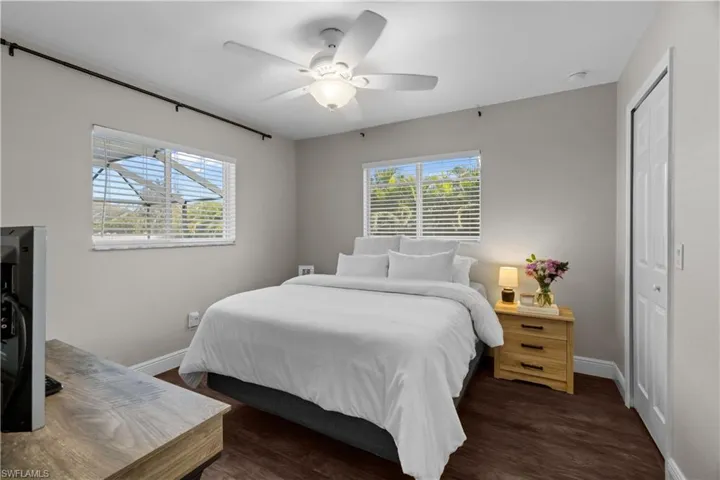 Bedroom with dark wood finished floors, a closet, and ceiling fan