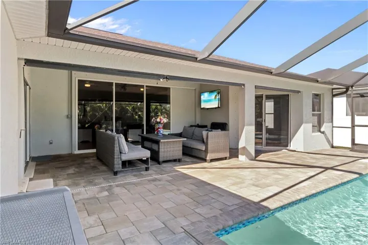 View of patio with a lanai, a sunroom, outdoor lounge area, and an outdoor pool