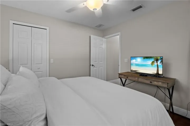 Bedroom with a ceiling fan, a closet, and dark wood-style flooring