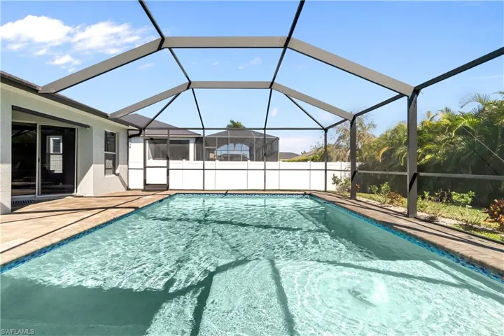 View of swimming pool featuring glass enclosure, a sunroom, and a patio area