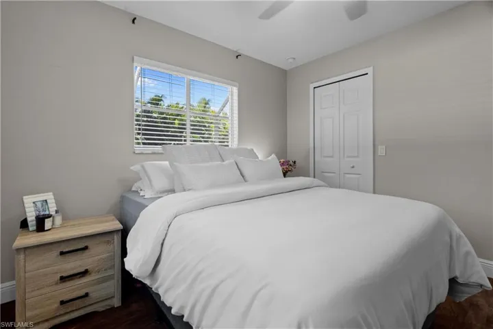 Bedroom with a closet, a ceiling fan, and dark wood finished floors