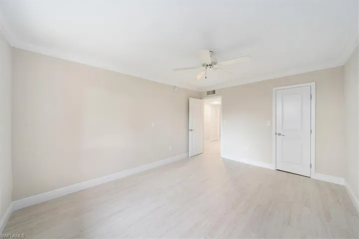 Empty room with ceiling fan, crown molding, and tile flooring