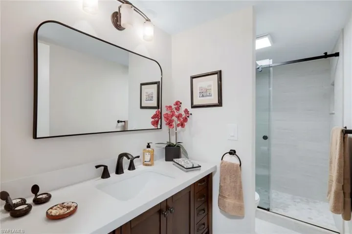 Bathroom with an enclosed shower, vanity, and toilet