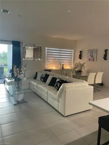 Living room featuring light tile patterned flooring and recessed lighting