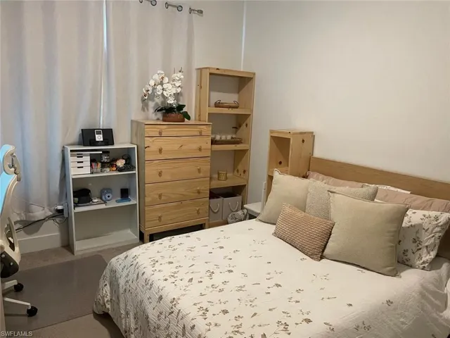 Carpeted bedroom featuring an office area