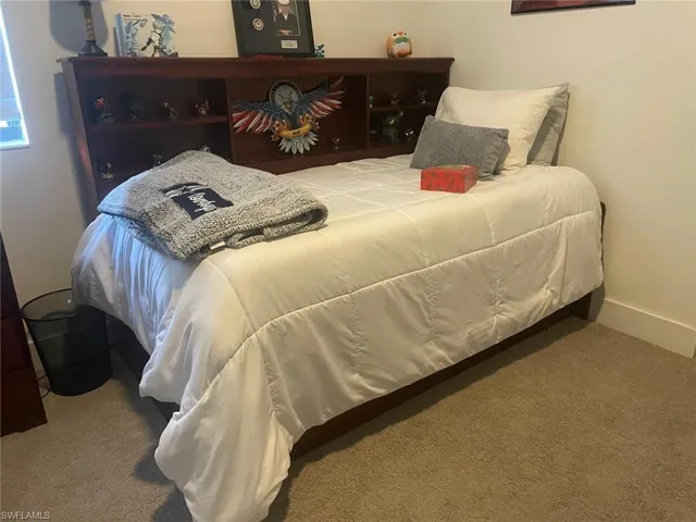 Bedroom with light colored carpet and baseboards