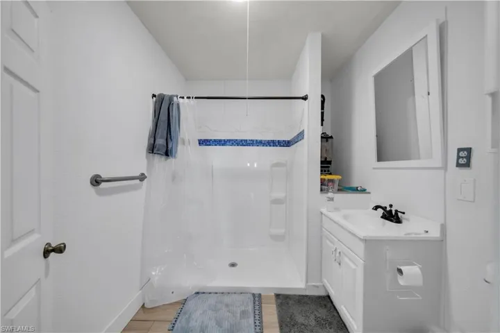 Full bath with a stall shower, light wood-type flooring, and vanity