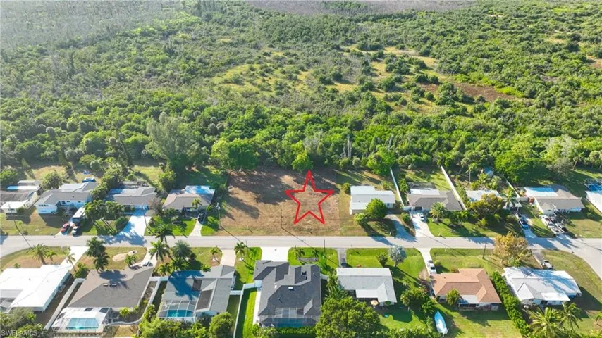 Aerial view of residential area featuring a heavily wooded area