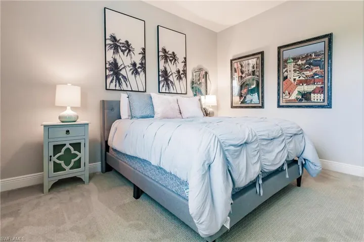 Bedroom with baseboards and light colored carpet