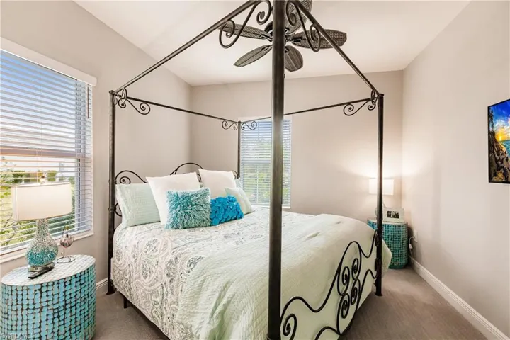 Carpeted bedroom featuring a ceiling fan and baseboards