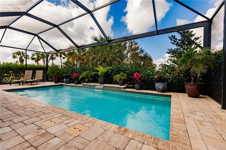 Outdoor pool featuring a lanai, a sunroom, and a patio area