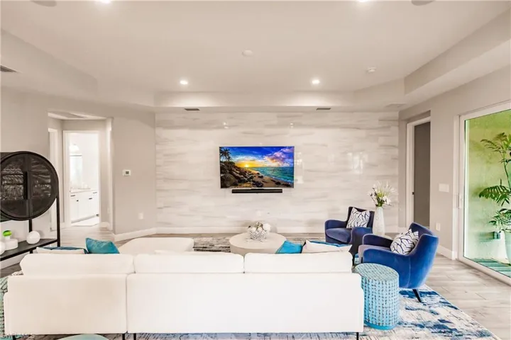 Living room featuring wood finished floors, recessed lighting, and an accent wall