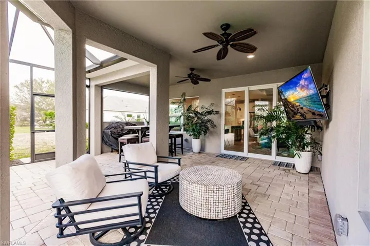 View of patio featuring a ceiling fan, glass enclosure, and a sunroom